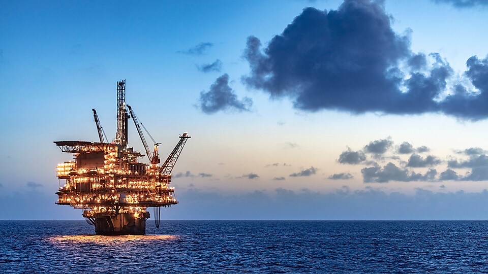 Офшорна нефтена платформа в морето осветява нощта