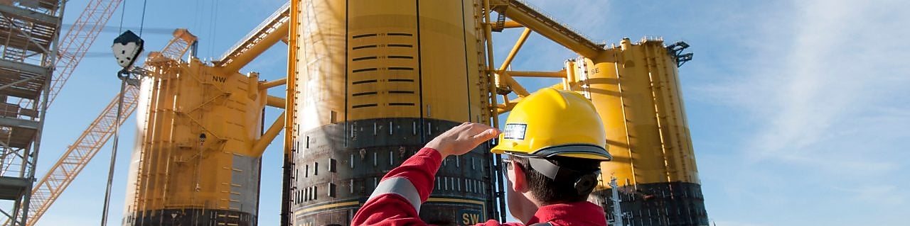 Инженер, гледащ нагоре към платформа в процес на изграждане