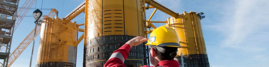 Инженер, гледащ нагоре към платформа в процес на изграждане