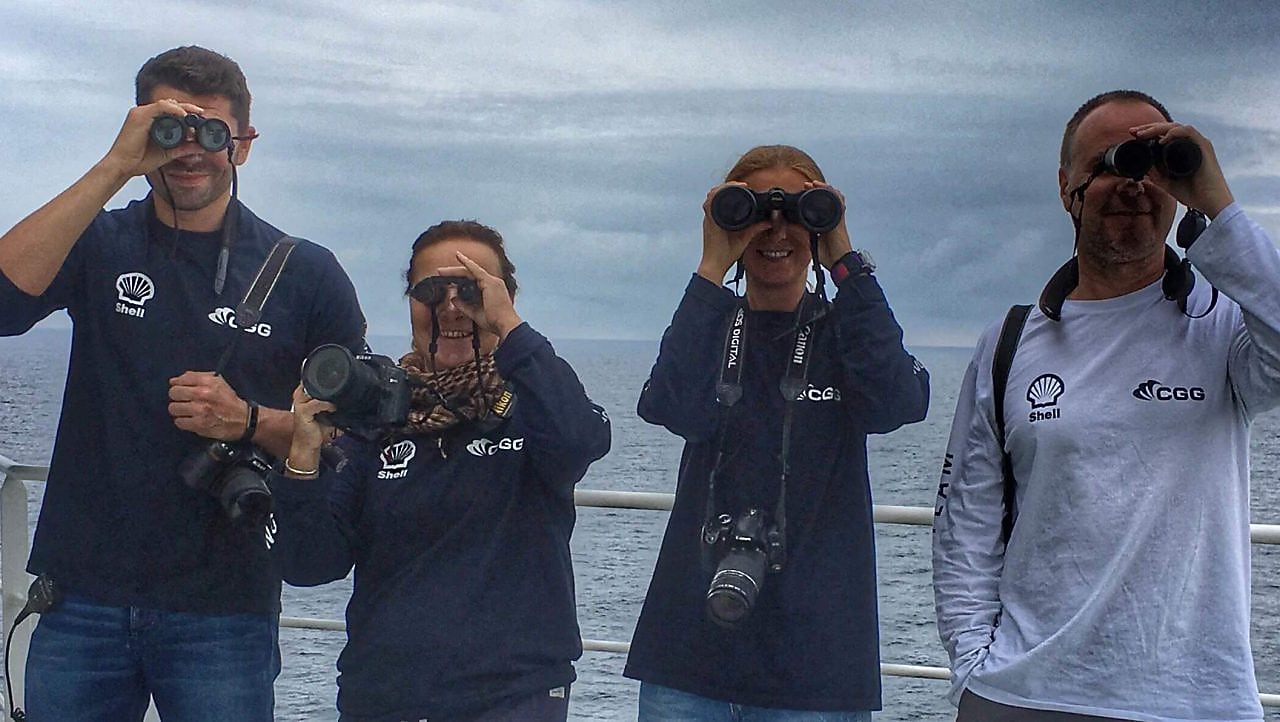 people in a ship looking through binoculars