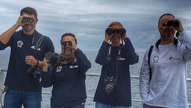 people in a ship looking through binoculars