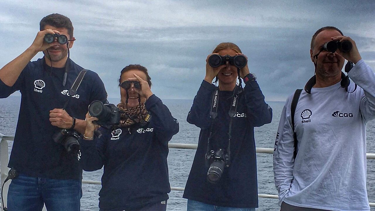 people in a ship looking through binoculars
