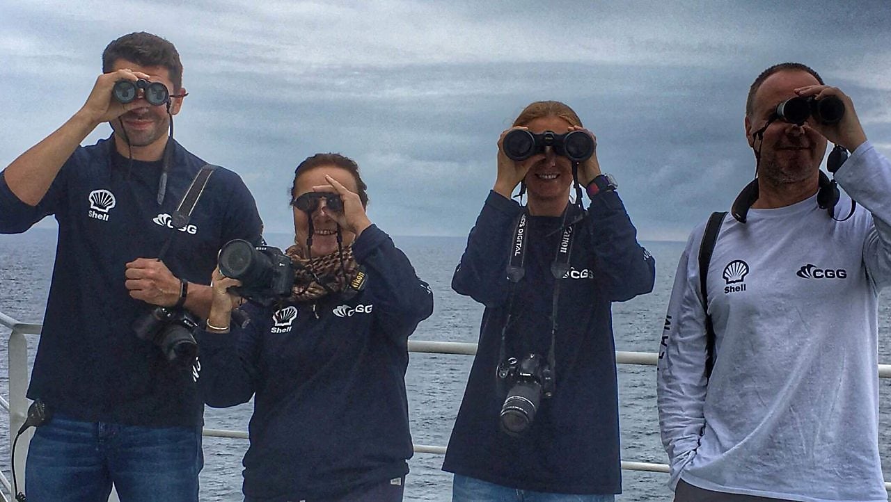 people in a ship looking through binoculars