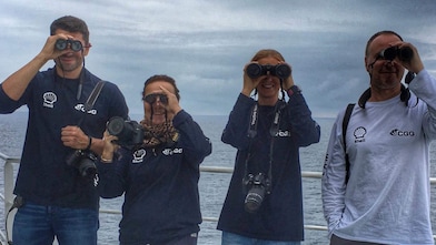 people in a ship looking through binoculars