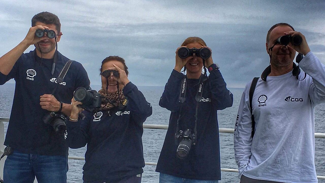 people in a ship looking through binoculars