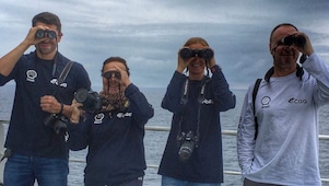 people in a ship looking through binoculars