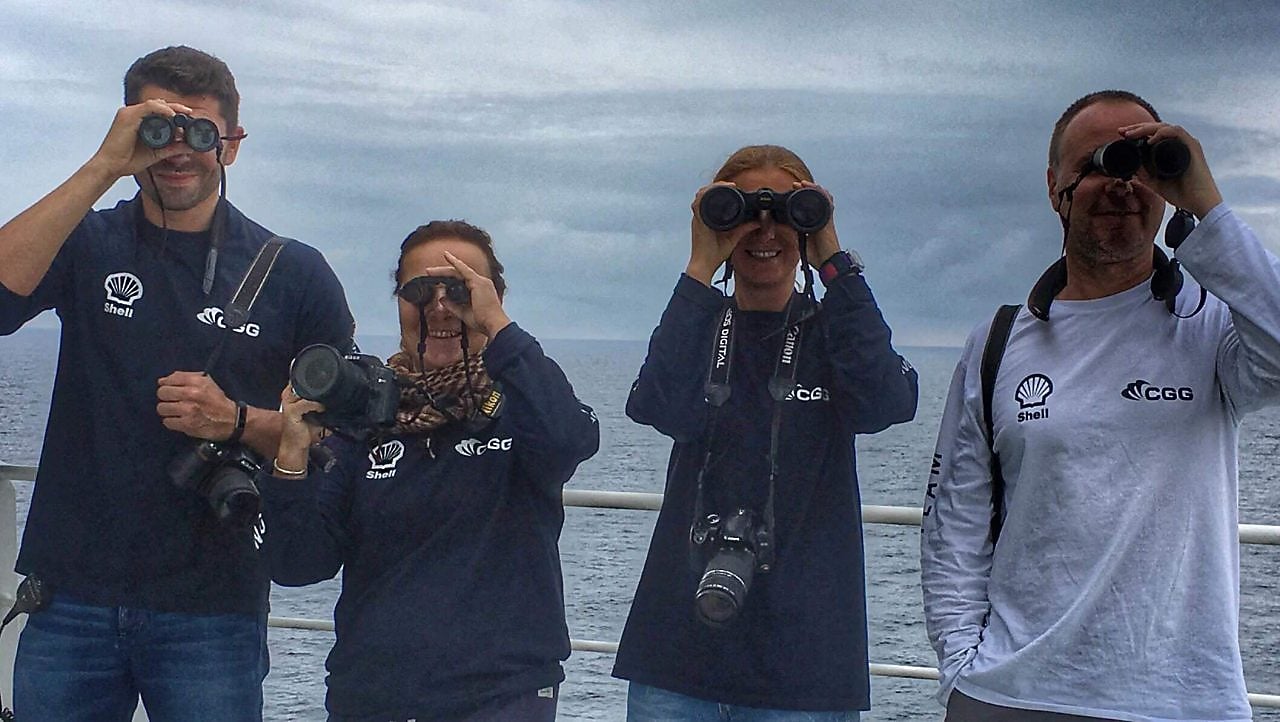 people in a ship looking through binoculars