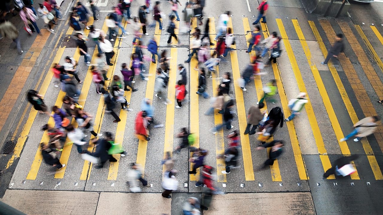 Хора пресичат оживена улица в Хонг Конг