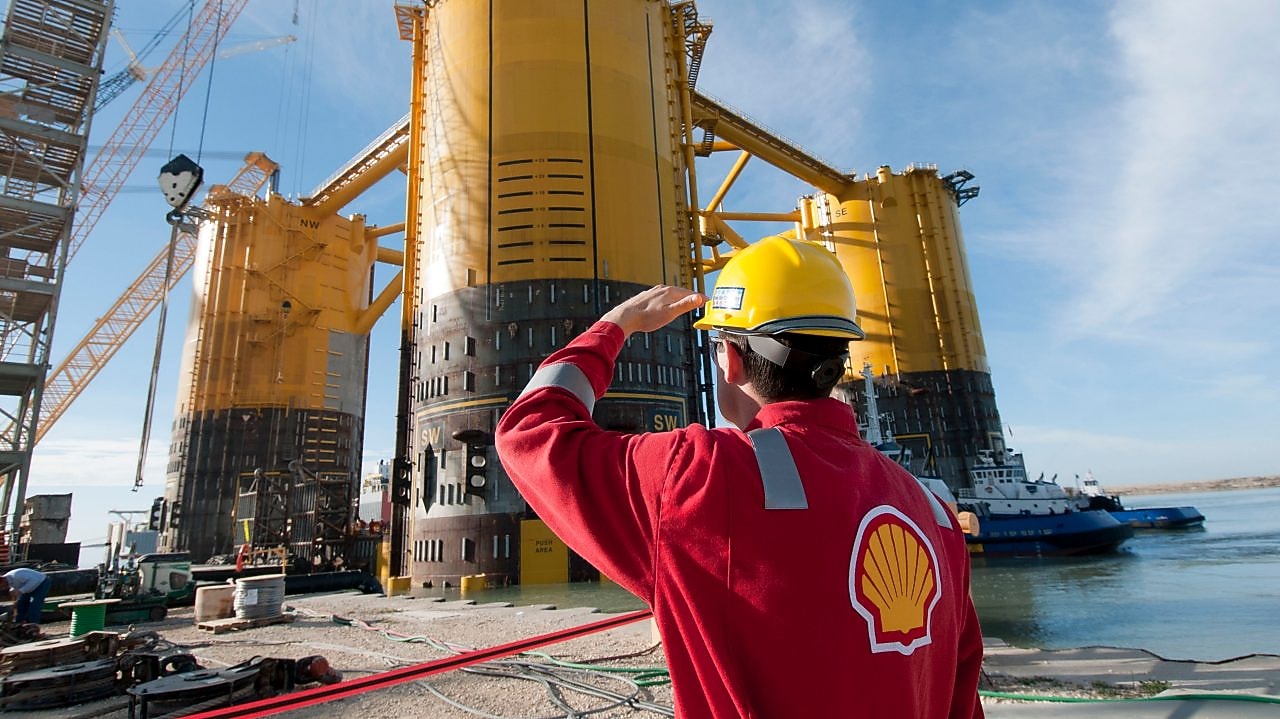 engineer in red uniform with yellow hard hat by marsb platform construction