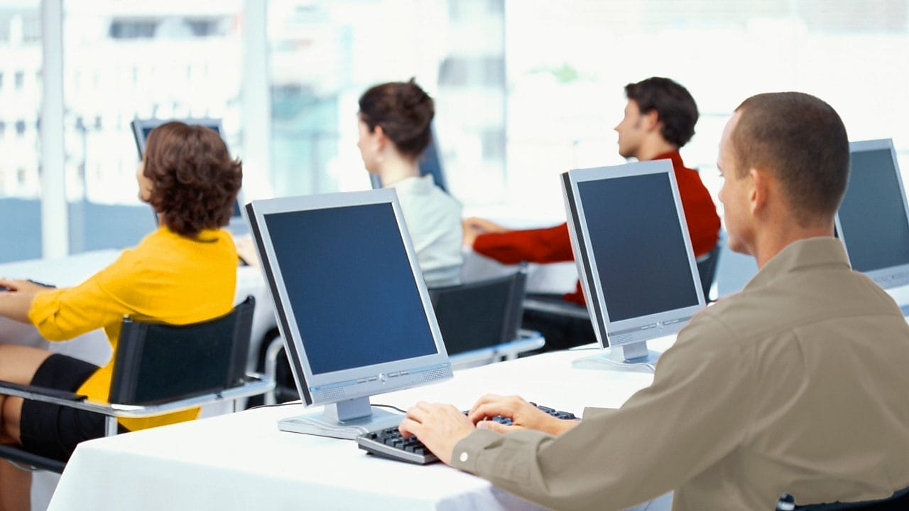 Служители, използващи компютри в офис
