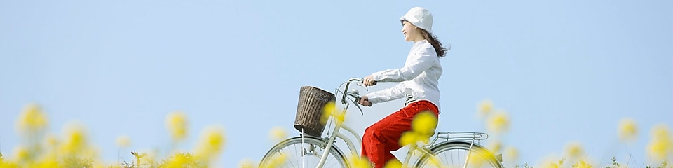 Млада жена кара колело в поле през лятото