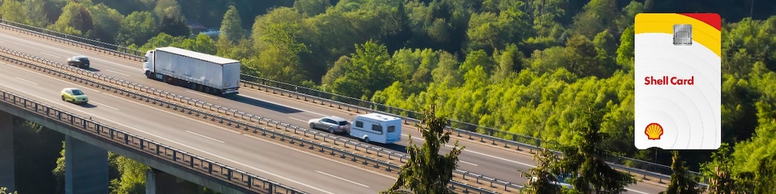 Камион се движи по криволичещ път в зелени полета. От дясната страна е изобразена карта Shell.