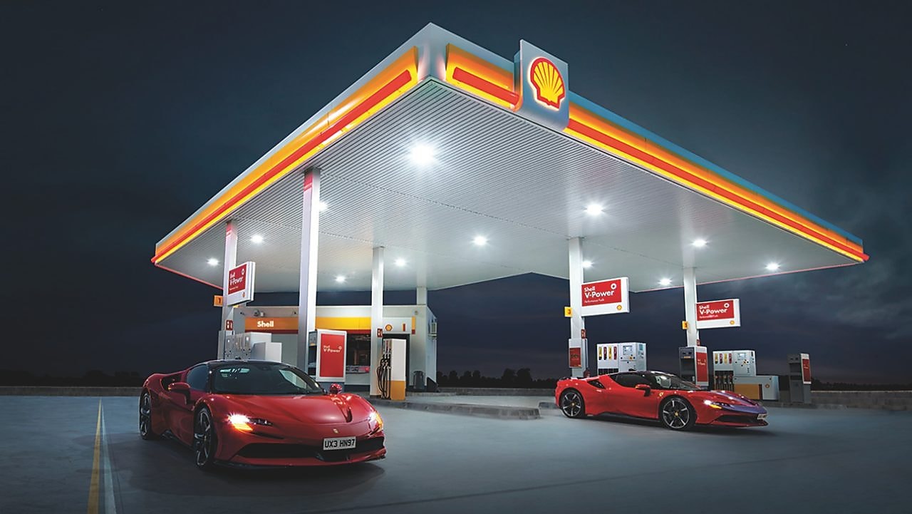 Dwa czerwone Ferrari na stacji benzynowej Shell