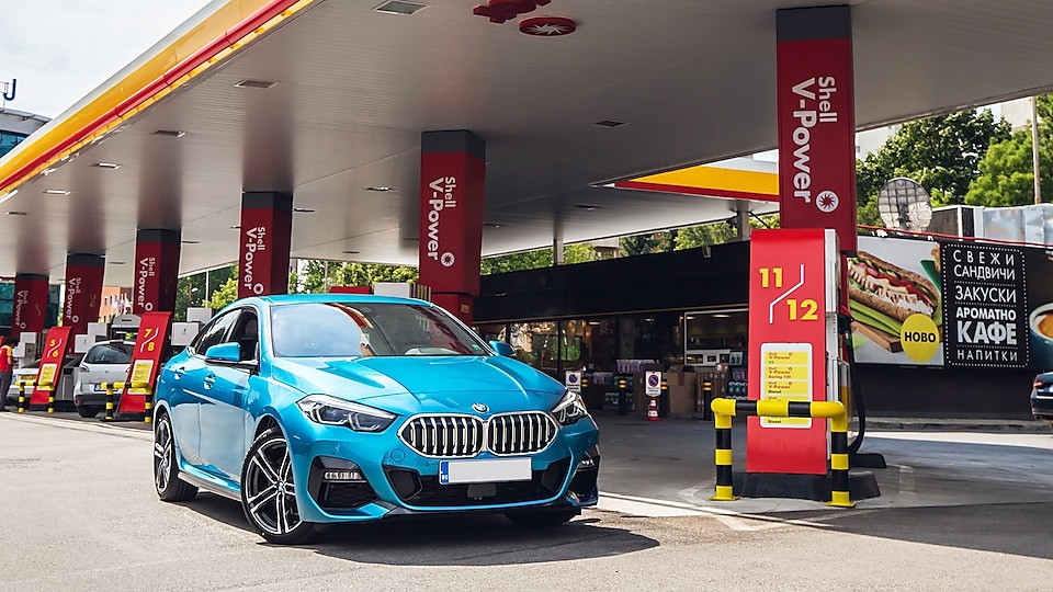 Cyan BMW car at shell gas station